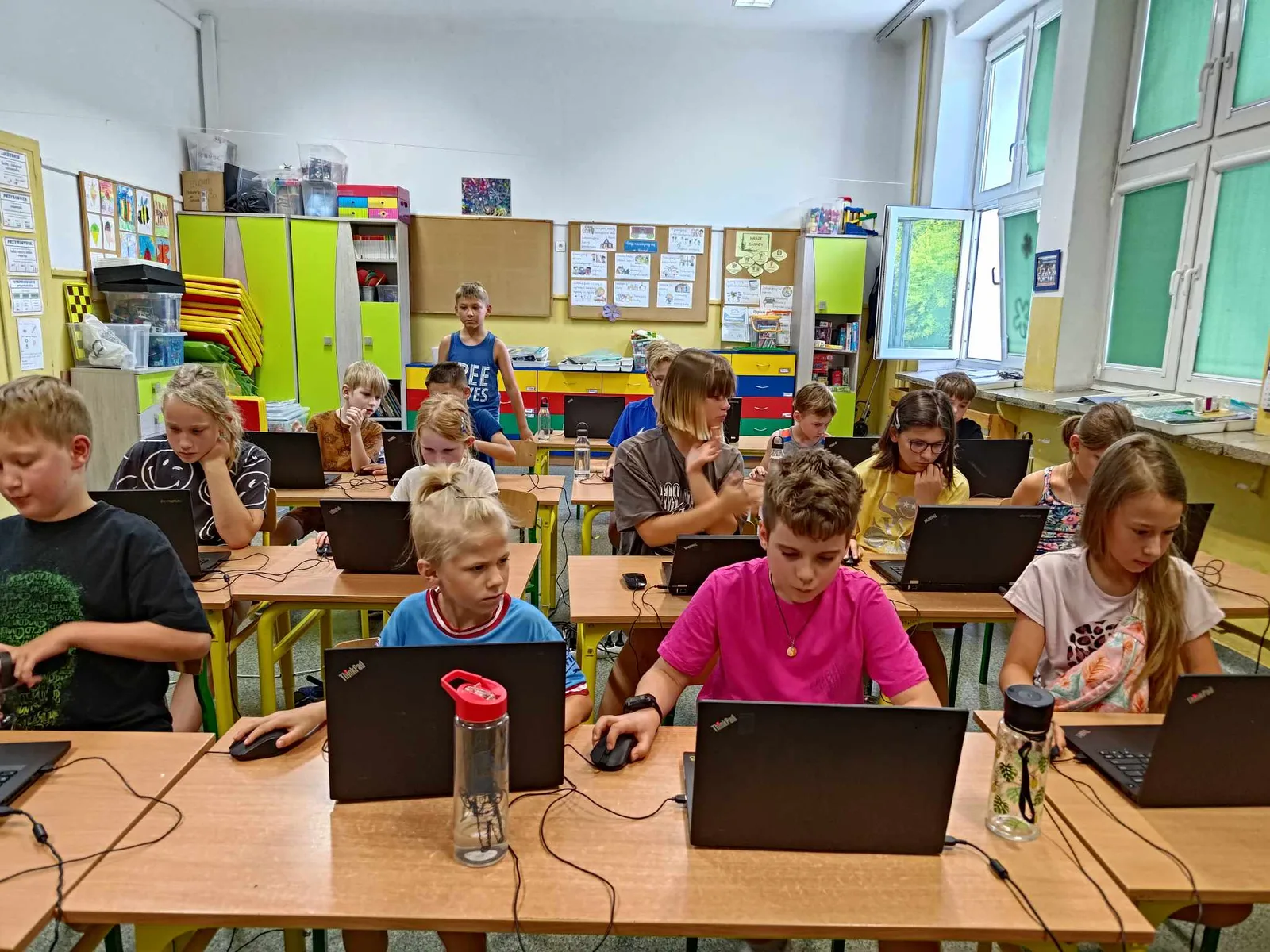 Klasa pełna dzieci przy laptopach podczas zajęć z programowania w Minecrafcie